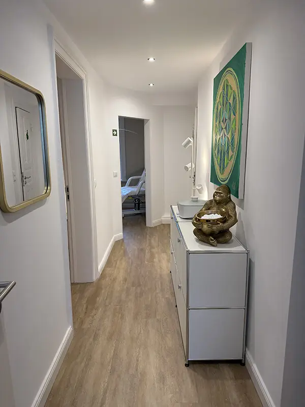 Heller Flur mit weißer Kommode, Spiegel, Bild und Statue mit Visitenkarten