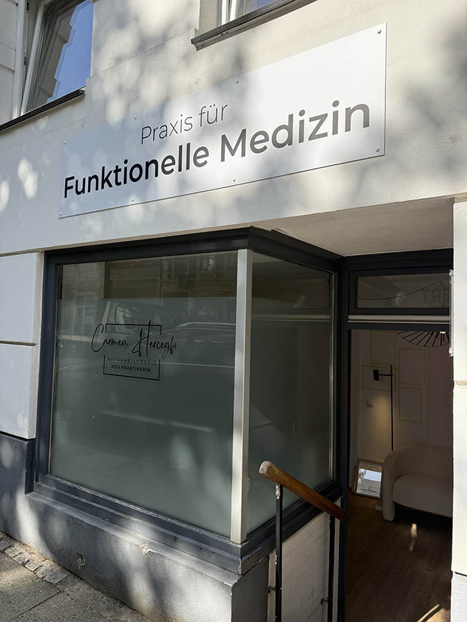 Eingangsbereich der Praxis mit Schild Funktionelle Medizin und Schaufenster