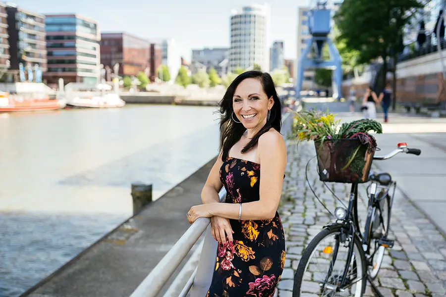 Carmen Hercegfi lachend im Sommerkleid in der Hafencity